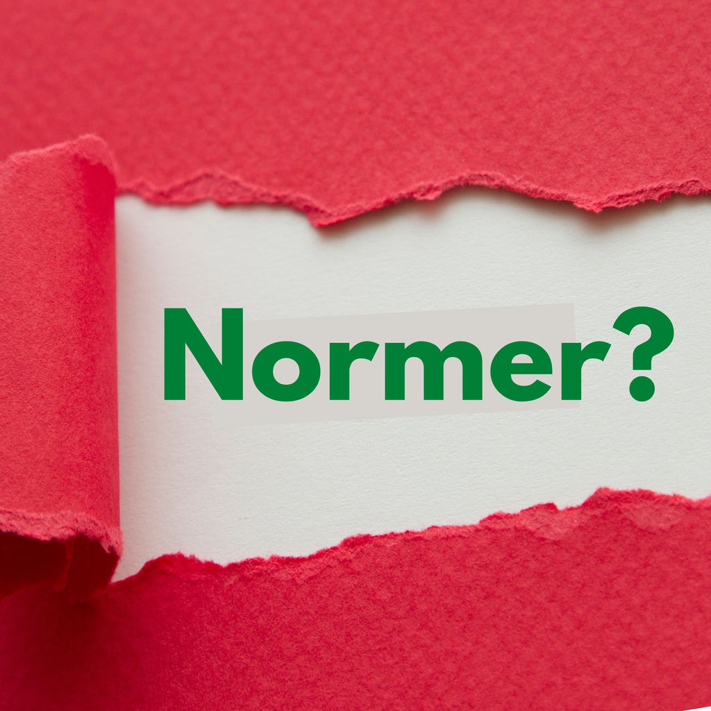 Ett vitt papper med texten "Normer?" skymtar under en röd papperslucka