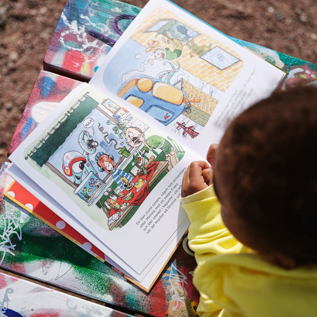 Ett barn tittar ner på illustrationer från Familjejakten - Bilderbok 3-6 år - OLIKA förlag - Författare: Jesper Lundqvist Illustratör: Daniel Sjö