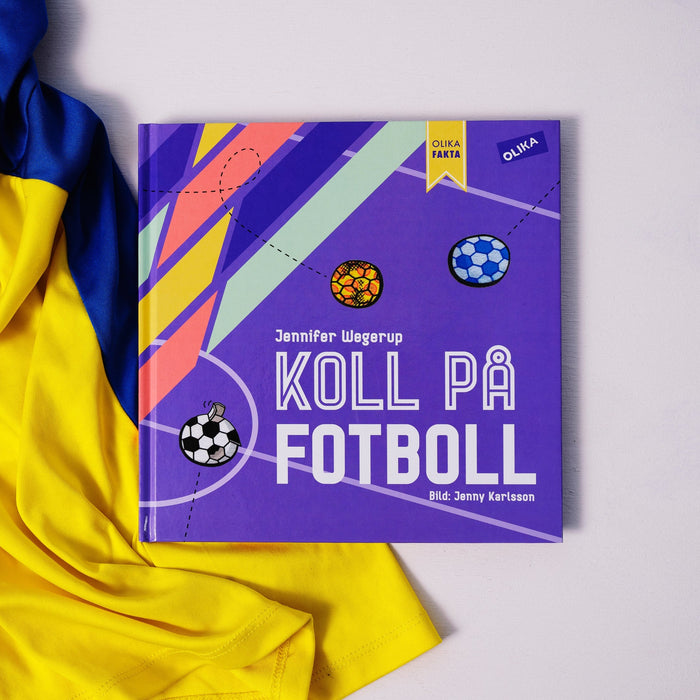 Kapitelboken Koll på fotboll ligger delvis på vit yta delvis på en blågul fotbollströja