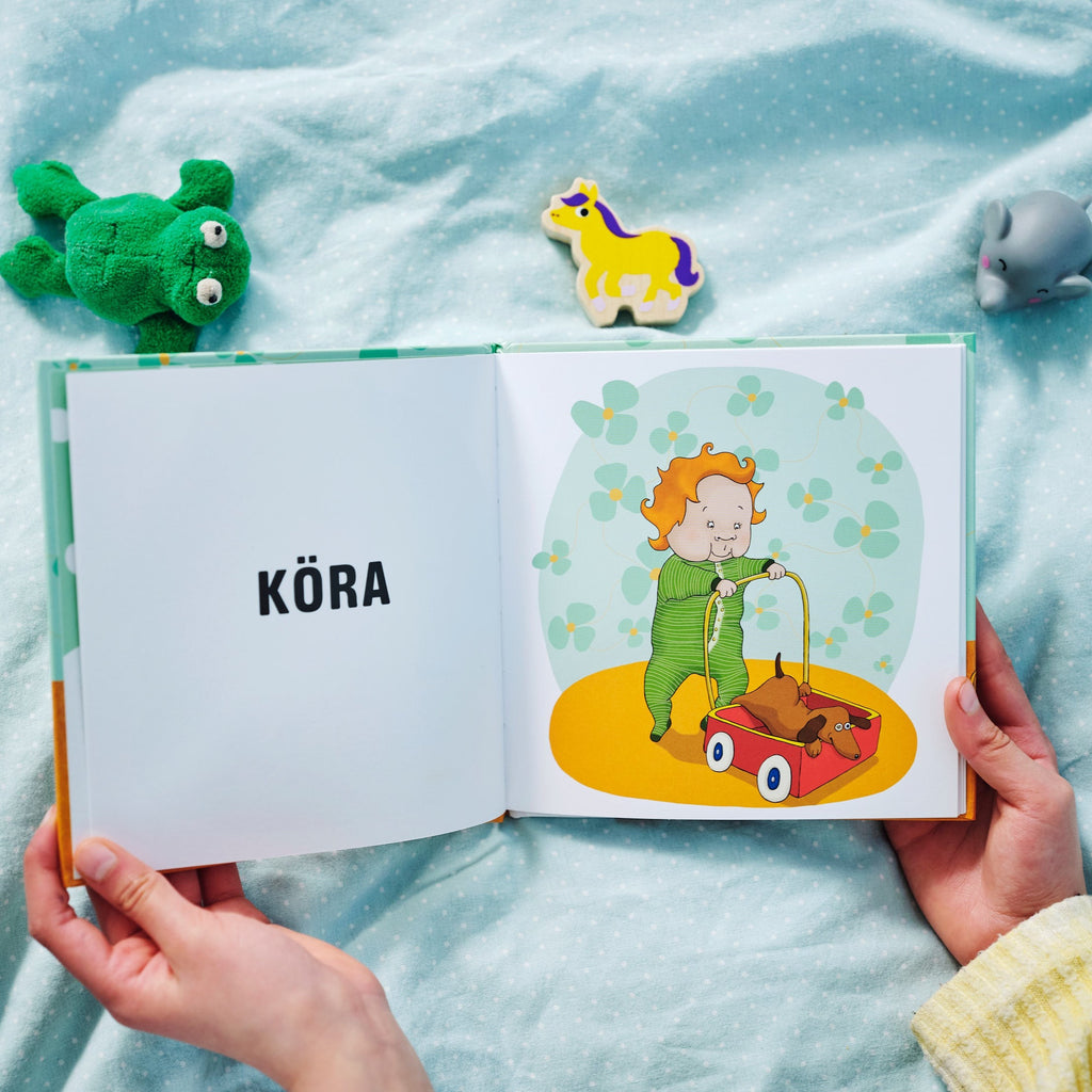 En illustration föreställande ett barn med en gåvagn ur Leka inne - Pekbok 0-2 år - OLIKA förlag - Författare: Marin Salto - Illustratör: Maja-Stina Andersson