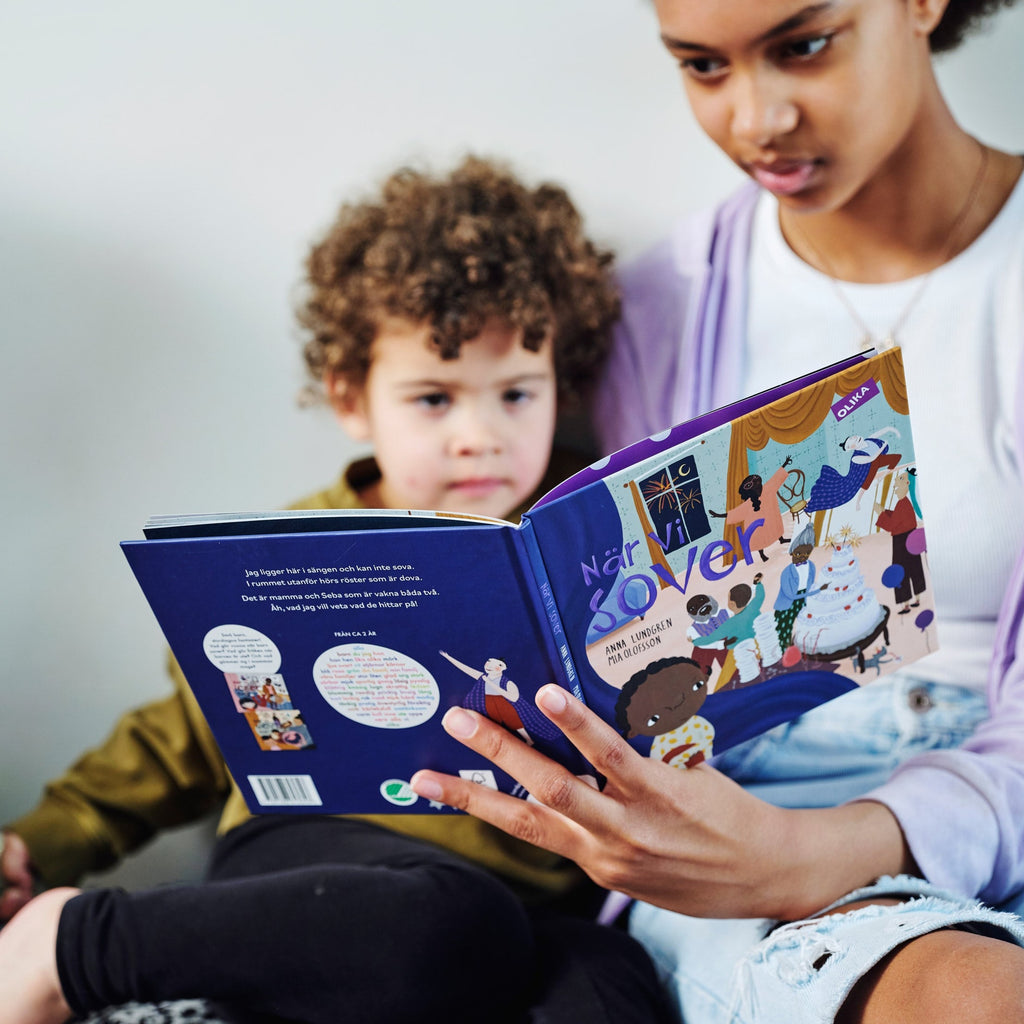 En ungdom och ett barn läser tillsammans i När vi sover - Bilderbok 1-3 år - OLIKA förlag - Författare: Anna Lundgren - Illustratör: Mia Olofsson