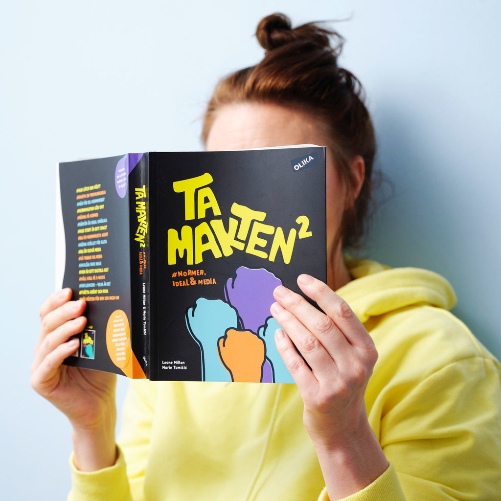 En person i gul luvtröja läser i Ta makten #normer, ideal & media - 13+ - OLIKA förlag - Författare: Leone Milton och Marie Tomicic - Illustratör: Fanny Agazzi