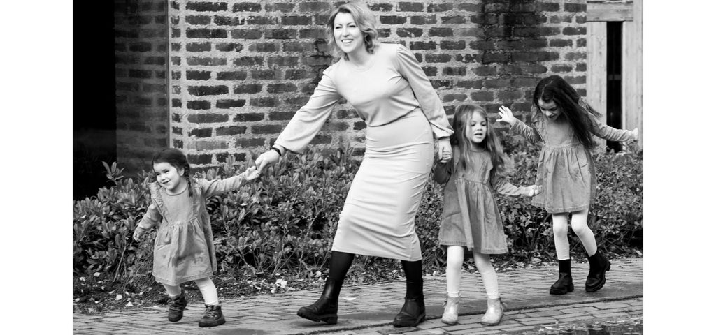 Svartvitt foto av Emmeli Thorselius som är ute och går med tre av sina barn