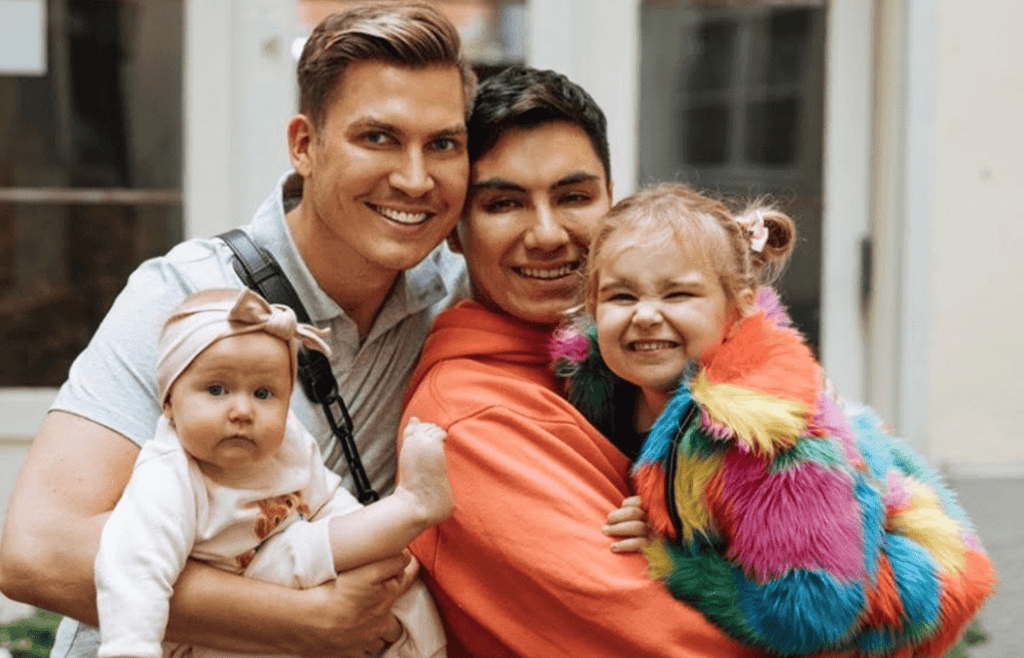 Färgfoto av Johan och John Valencia med sina två barn Miriam och Astrid i famnen. De står utomhus