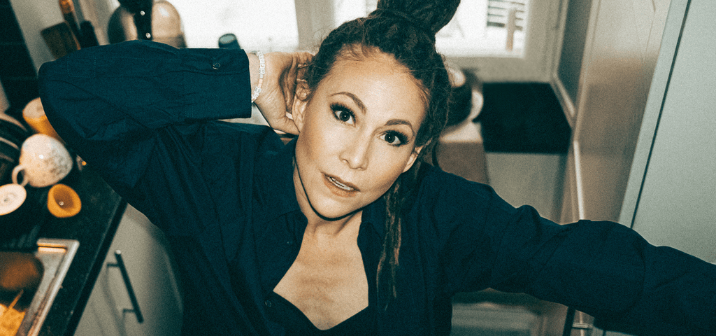 Färgfoto av  Mariette som står inomhus och ser in i kameran