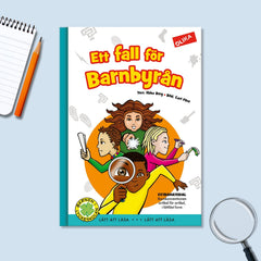 Bilderboken Ett fall för Barnbyrån på blå yta på varsin sida om boken ligger ett förstoringsglas och ett block med penna