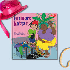 Bilderboken Farmors hattar på blå yta. På bokryggen sitter en rosa paljetthatt och i hörnet syns ett gult pärlhalsband.
