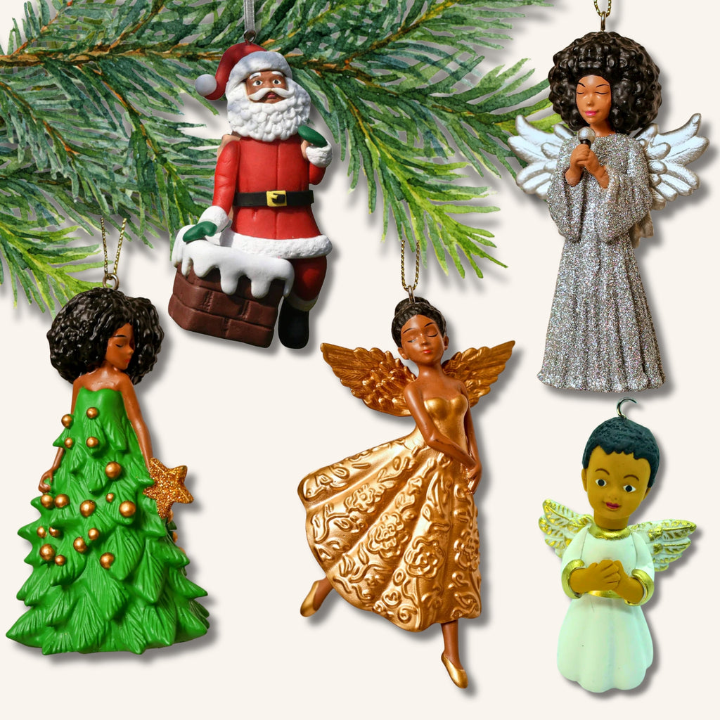 Fem juldekorationer med brun hudfärg – en tomte, tre änglar och en kvinna i julgransklänning – upphängda på en grankvist.