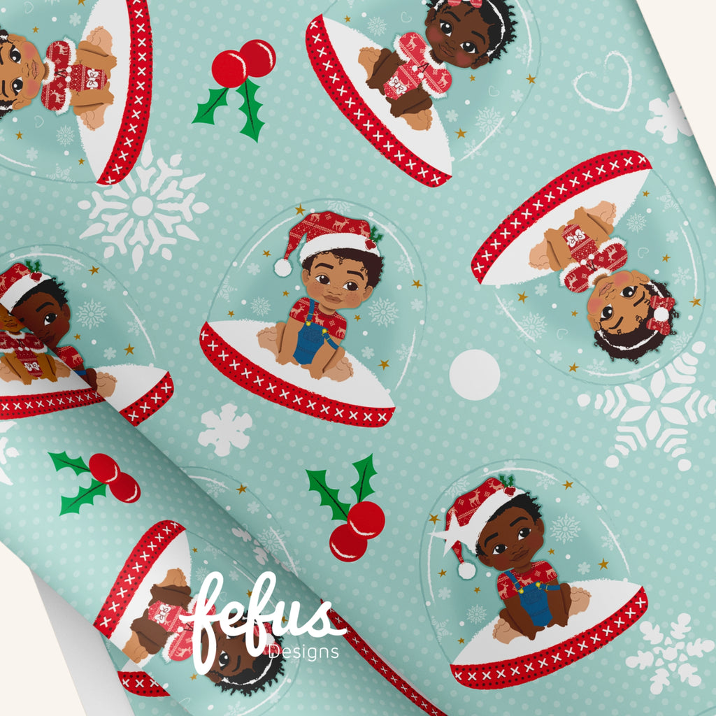 Julpapper med illustrationer av barn med brun hudfärg och texten ”FEFUS DESIGNS” tryckt på bilden