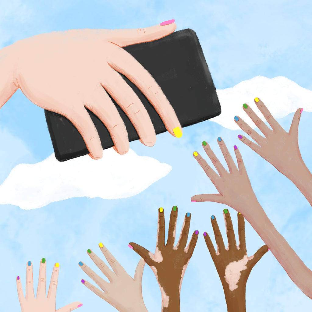 Uppsträckta händer med regnbågsfärgade naglar och mobil som fotar
