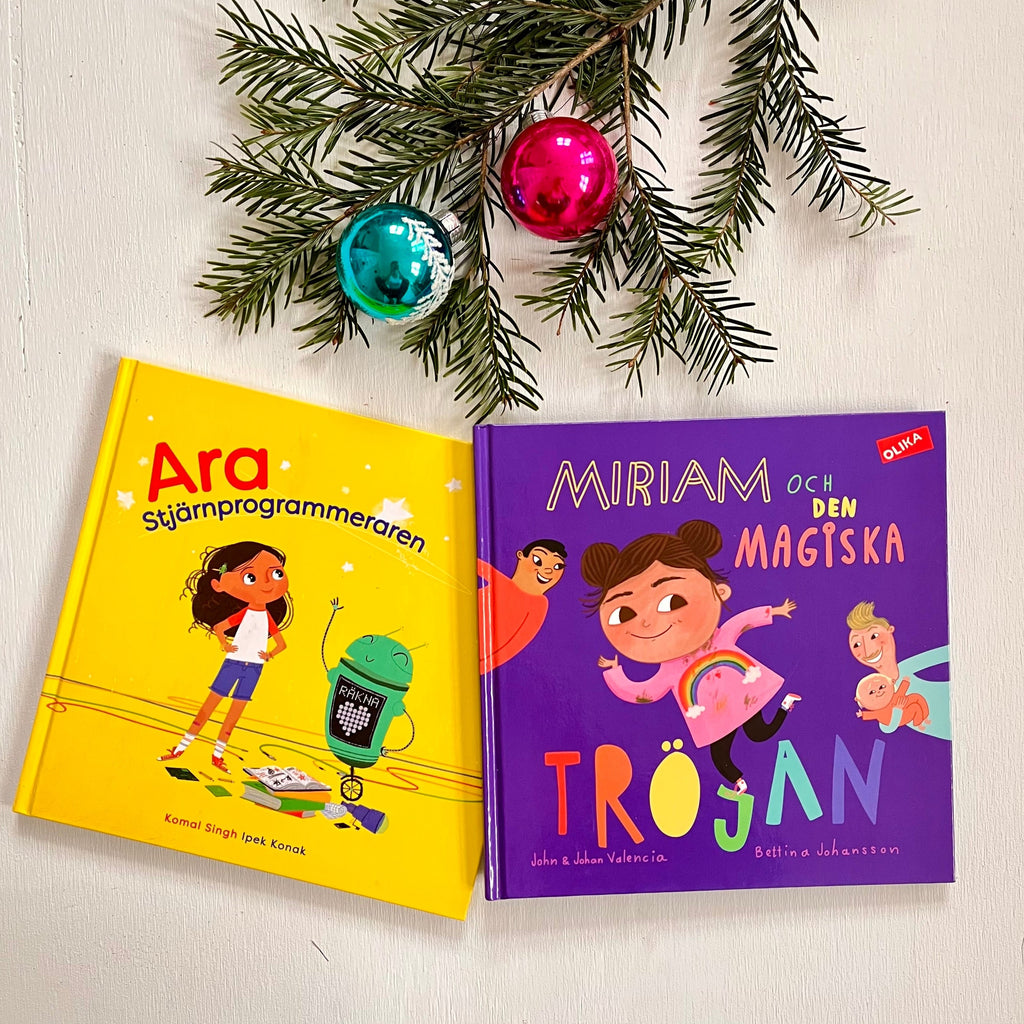 Böckerna Ara stjärnprogrammeraren och Miriam och den magiska tröjan ligger på ett bord. En grankvist med juldekorationer syns.