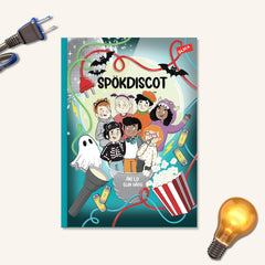 Lätt att läsa boken Spökdiscot på vit yta. I ena hörnet syns en sladd i andra hörnet en glödlampa
