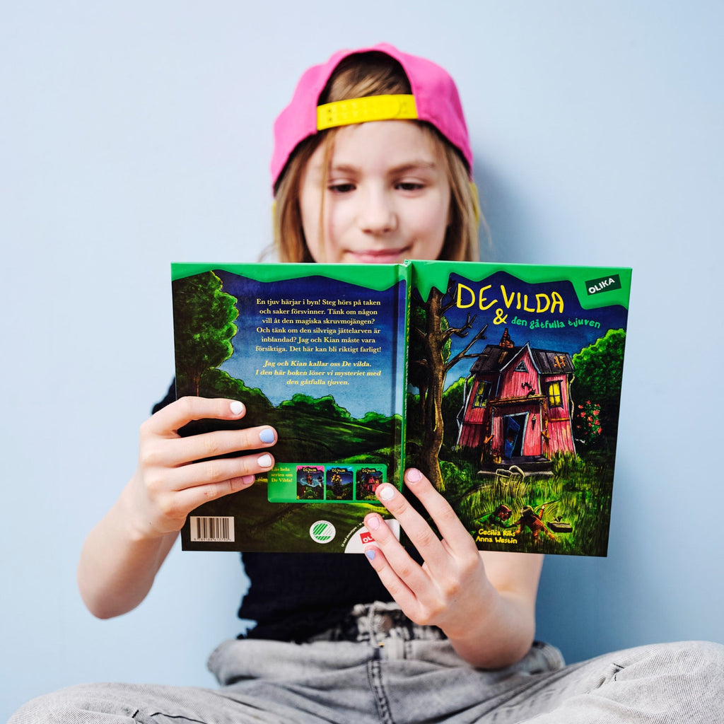 Ett barn läser i De vilda & den gåtfulla tjuven -  6-9 år  - OLIKA förlag - Författare: Cecilia Rihs - Illustratör: Anna Westin