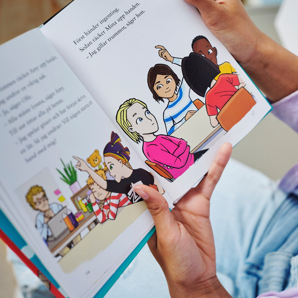 Ett barn håller upp ett av uppslagen i boken Du är en stjärna, Amy Jönsson! - Barnen i Lyckeskolan - Lättläst 6-9 - OLIKA förlag - Författare: Ebba Berg - Illustratör: Carl Flint