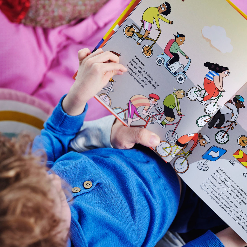 Ett barn tittar ner på bilderna i Kluriga ordens ABC - Bilderbok 3-6 år - OLIKA förlag - Författare: Mia Kim Illustratör: Maria Källström