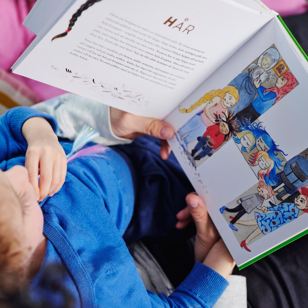 Ett barn sitter i en vuxens knä och tillsammans läser de i Kroppens ABC - Bilderbok 3-6 år - OLIKA förlag - Författare: Lina Boozon Ekberg, Eva Emmelin och Linda Madsen - Illustratör: Alaya Vindelman