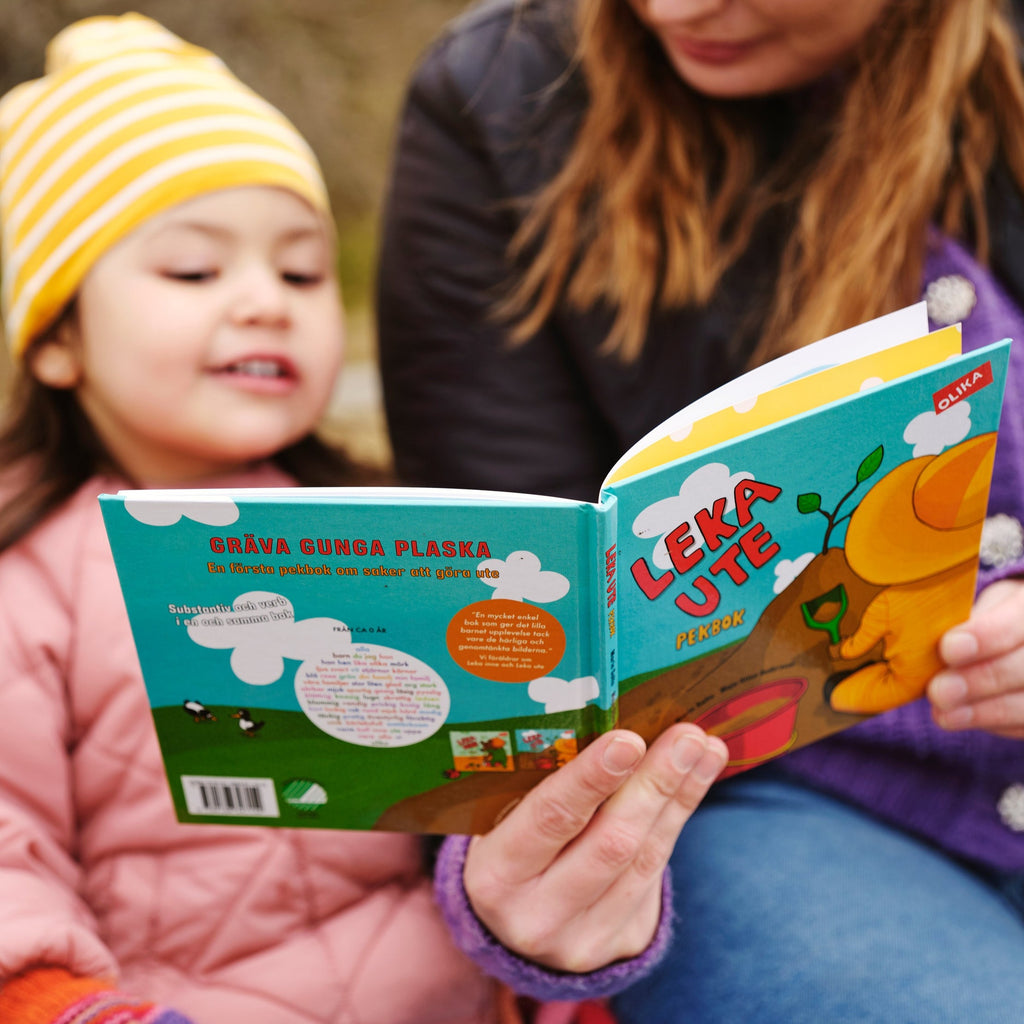 En vuxen och ett barn läser tillsammans i Leka ute - Pekbok 0-2 år - OLIKA förlag - Författare: Marin Salto - Illustratör: Maja-Stina Andersson