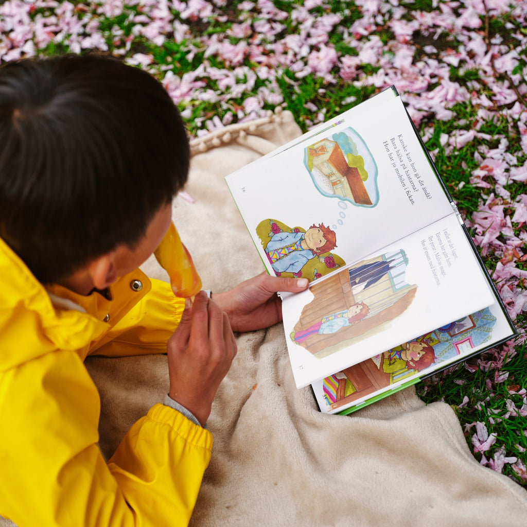 Ett barn bläddrar i en kopia av Malva i stallet - Lättläst 6-9 år - OLIKA förlag - Författare: Malin Eriksson - Illustratör: Lisa Säfve Chantem