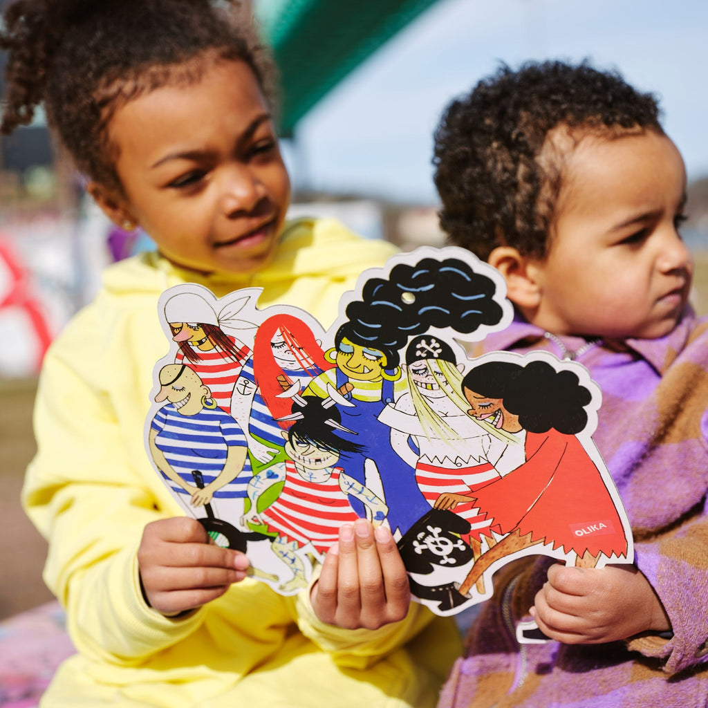 Två barn håller upp Pappfigur Piraterna - Storlek: ca 35 cm hög - Miljömärkt: Svanen - OLIKA förlag