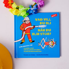Bilderboken Vad vill du bli när du blir stor? 3 titlar i en bok! på vit yta. En blomkrans & bygghjälm syns också

